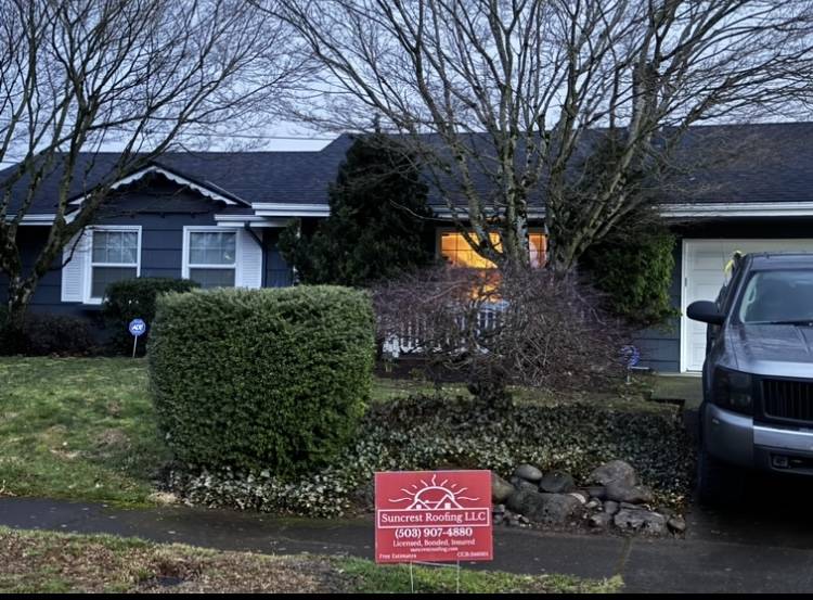 roof replaced by suncrest roofing with a red suncrest roofing sign in front of the homw