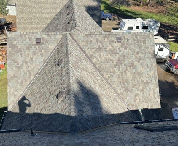 a man on a roof that was just installed using presidential shingles